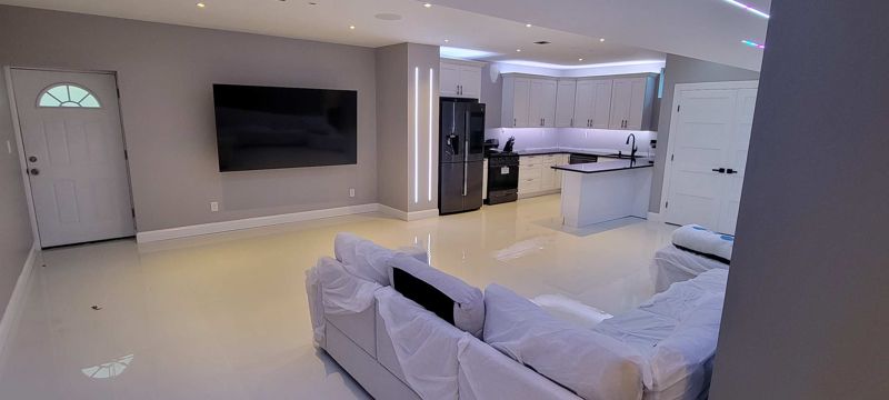 Interior photo of a living area with a sectional sofa and kitchen in Hicksville, NY