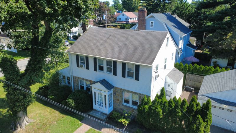 Drone photo of a white colonial home and its trees in Scarsdale, NY